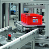 Red tote on a pallet conveyor that is rotating